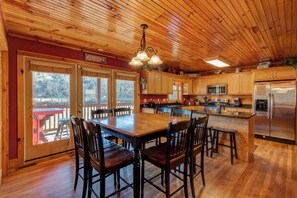 Une cuisine spacieuse avec des meubles en bois, un grand îlot central et un réfrigérateur en acier inoxydable.