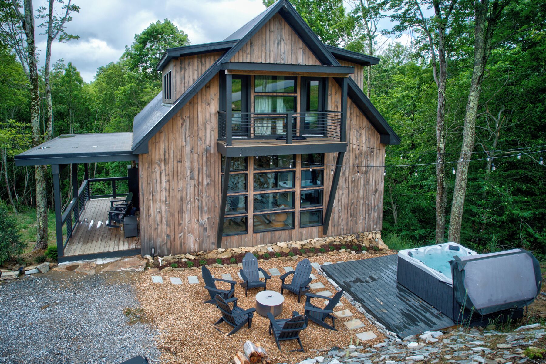 Une cabane dotée d’une terrasse, de meubles de jardin et d’un bain à remous.