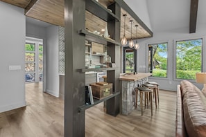 A spacious kitchen with a central island, large windows, and a view of greenery. - Three Bears Retreat at Monteagle (Banner Elk)
