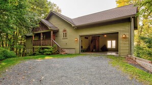 A two-story house with a front porch, a garage, and a covered outdoor area.
