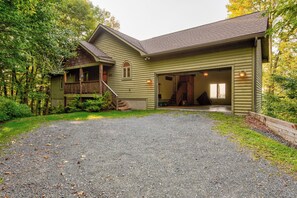 A two-story house with a front porch, a garage, and a covered outdoor area.