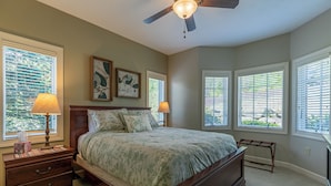 A bedroom with a bed, nightstands, lamps, and a ceiling fan. - Sugarjax at The Reserve (Banner Elk)