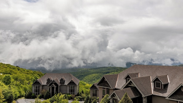 A residential area with houses featuring gabled roofs and a mountainous backdrop. - Sugarjax at The Reserve (Banner Elk)