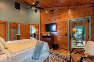 Un dormitorio con cama, televisión y vistas al exterior.