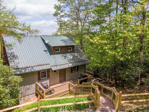 A cabin with a metal roof, wooden deck, and a small porch area. - Parkway Hideout (Boone)