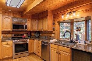Una cocina de madera con microondas, horno y lavavajillas integrados.