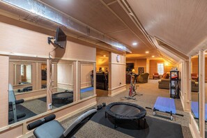 A gym with exercise equipment, mirrors, and a trampoline. - The Castle at Valle Crucis (Banner Elk)