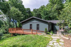 A house with a deck, surrounded by trees. - Snaggys Retreat (Boone)