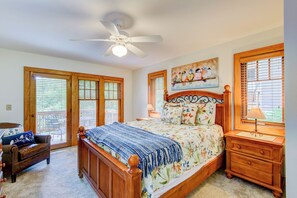 A bedroom with a bed, a nightstand, a chair, a ceiling fan, and a window with blinds. - Peace at Echota (Boone)