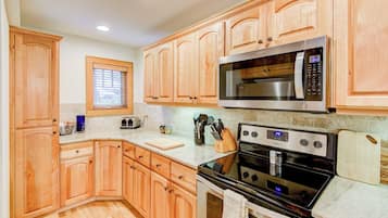 A kitchen with wooden cabinets, a microwave, an oven, and a toaster.