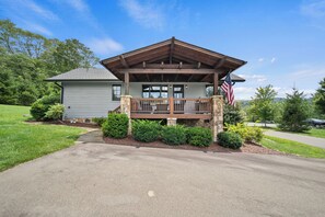 A house with a porch, a flag, and a stone foundation. - River Rock (Banner Elk)