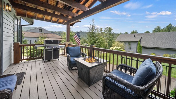 A covered deck with wicker furniture, a grill, and a fire pit. - River Rock (Banner Elk)