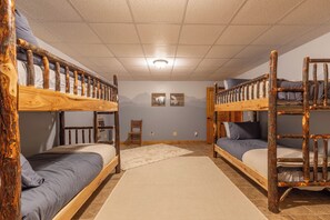 Ein Schlafraum mit Etagenbett, einem Holzkopfteil, einem Stuhl und einem Teppich.