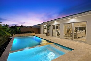 A modern house with a swimming pool, a patio, and a glass-enclosed living area. - Beach Bunny (Fort Lauderdale)