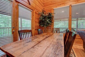 A wooden interior with a large dining table, chairs, and a potted plant. - Hebron Falls Cabin (Boone)