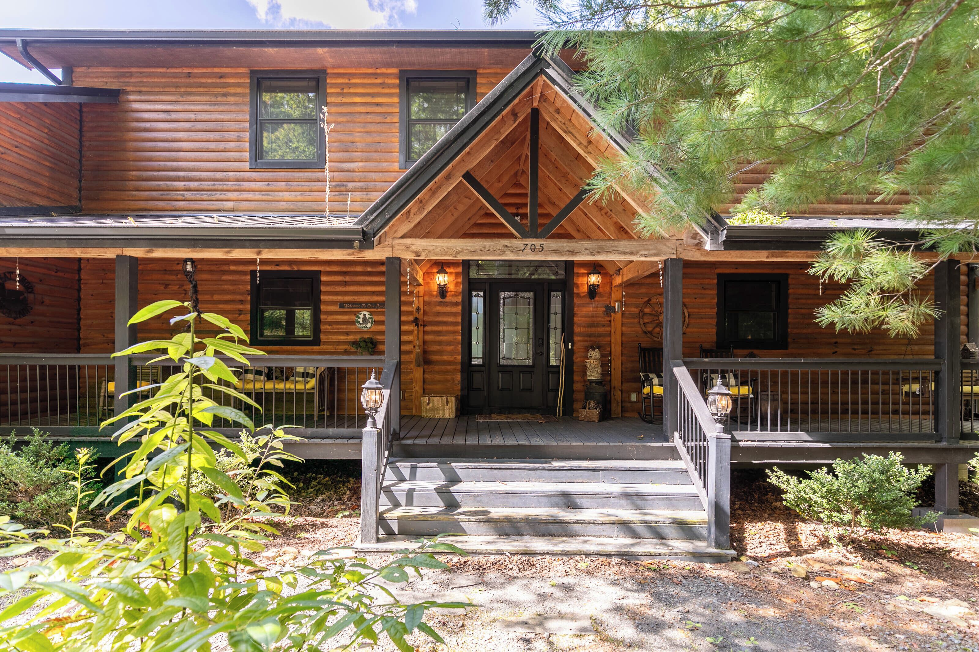A wooden cabin with a porch, a front door, and a number '705' on the front.