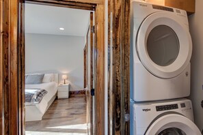 Un lavadero con dos lavadoras Whirlpool apiladas.