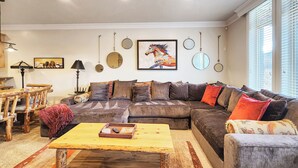 A living room with a sectional sofa, a coffee table, a lamp, and wall decorations. - 6486 Lakeside #15 (Huntsville)