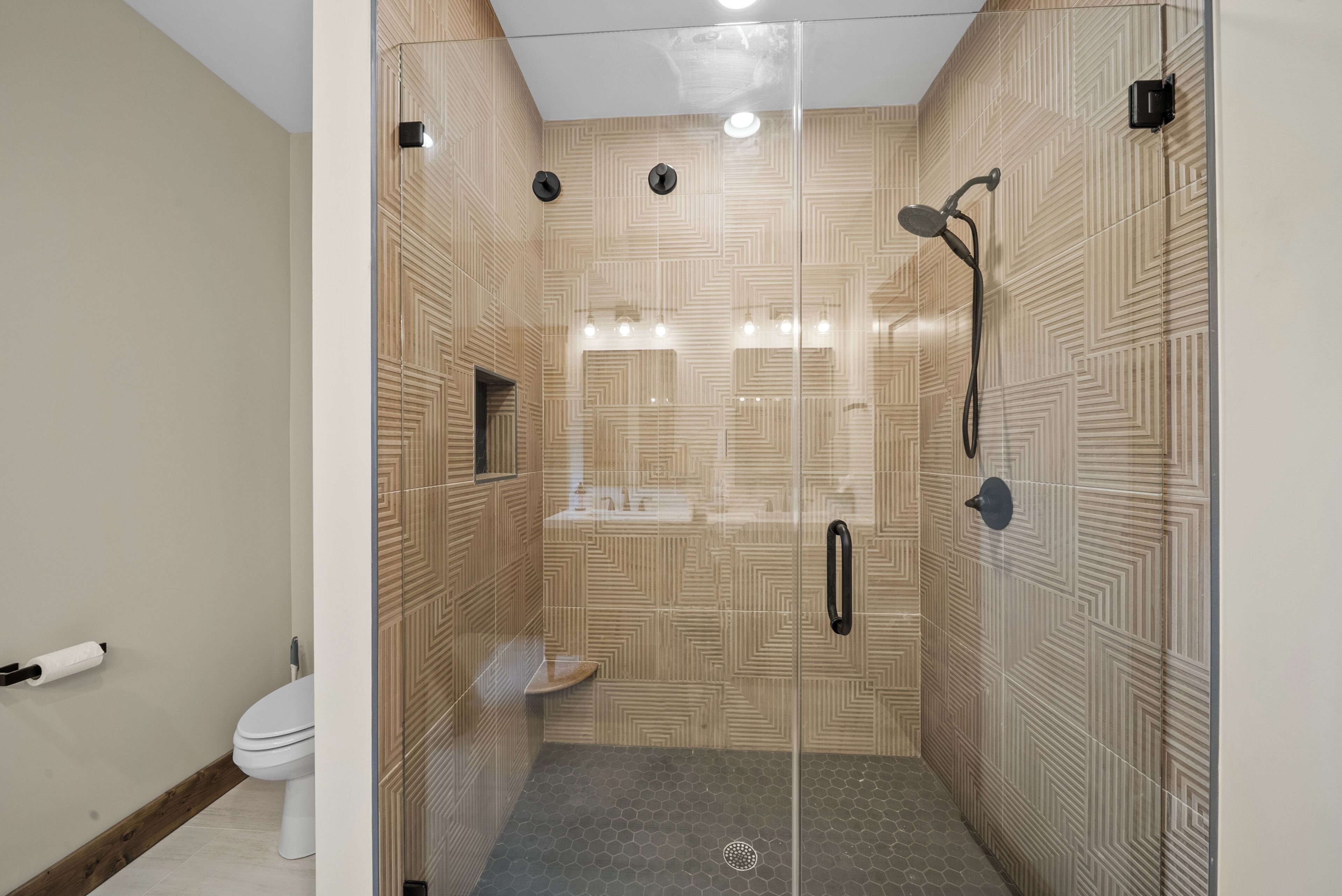 Un baño moderno con ducha de vidrio, inodoro y lavamanos.