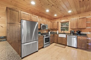 Una cocina moderna con armarios de madera, electrodomésticos de acero inoxidable y un ventanal con vistas.
