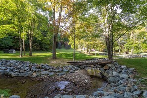 A natural landscape with a small stream, rocks, and trees. - Matney Ridge Estate (Banner Elk)