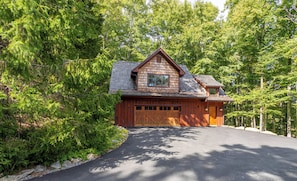 A wooden cabin with a garage, surrounded by dense forest. - Matney Ridge Estate (Banner Elk)