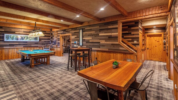 A cozy, rustic room with a pool table, a wooden dining table, and a bar area. - Matney Ridge Estate (Banner Elk)