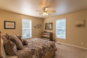 A bedroom with a bed, dresser, ceiling fan, and two windows with blinds. - 4 Bears Lodge (Banner Elk)