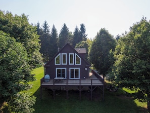 A two-story house with a deck, surrounded by trees. - 4 Bears Lodge (Banner Elk)