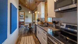 A modern kitchen with stainless steel appliances, wooden ceiling, and a rustic decor. - Valley View (Banner Elk)
