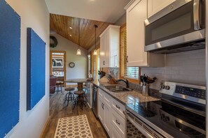 A modern kitchen with stainless steel appliances, wooden ceiling, and a rustic decor. - Valley View (Banner Elk)