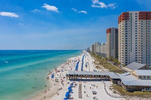 Ein Hotel am Strand mit einem langen Sandstrand, Blick auf den Ozean und Hochhäusern im Hintergrund.