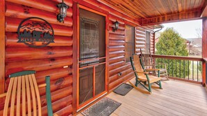 Eine Holzhütte mit Veranda, Fußmatte und zwei Schaukelstühlen.