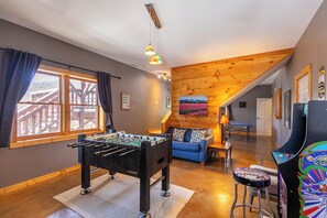 Ein gemütliches Zimmer mit einem Tischkicker, einem blauen Sofa und einer farbenfrohen Spieluhr.