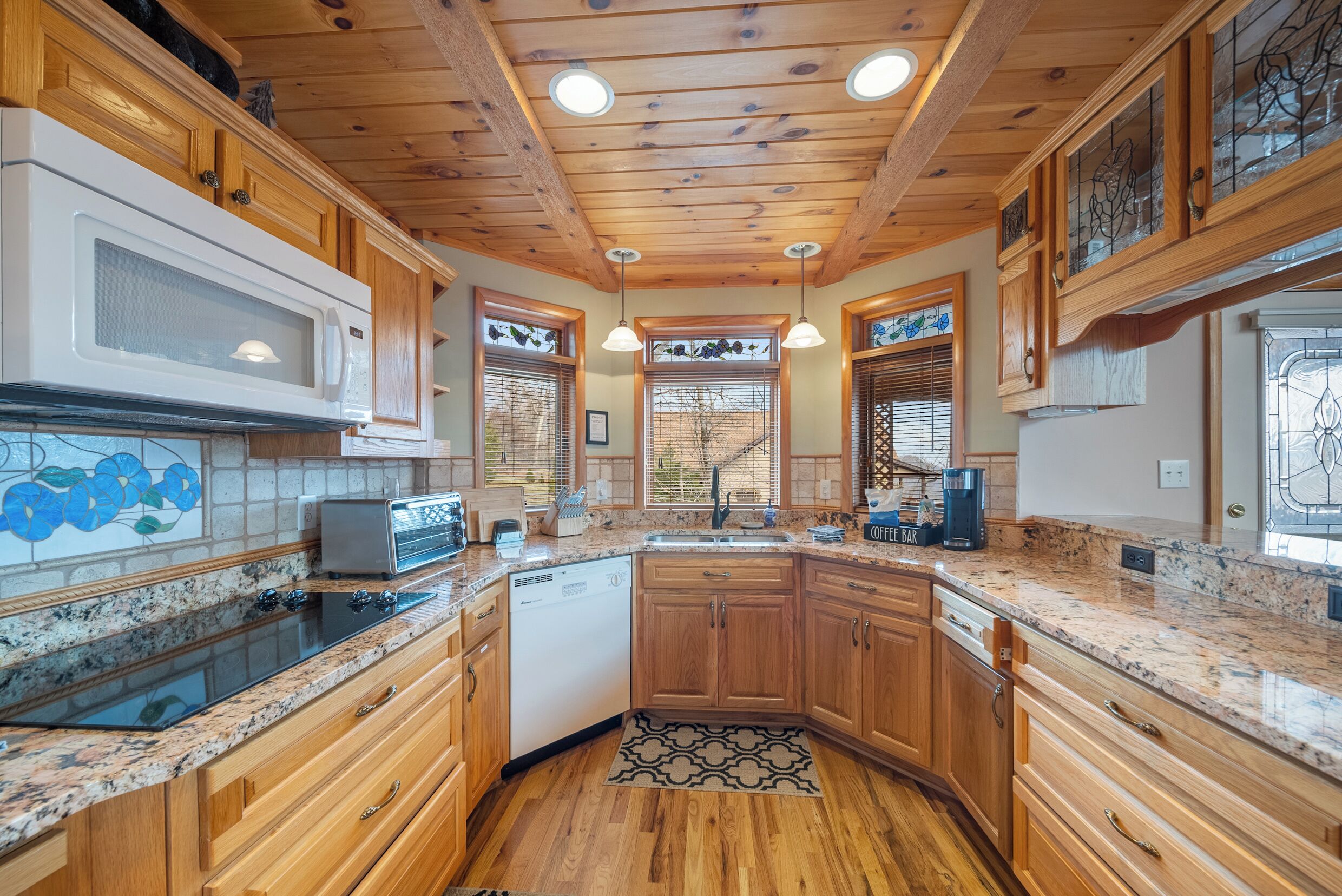 A kitchen with wooden cabinets, a microwave, a toaster, and a coffee maker.