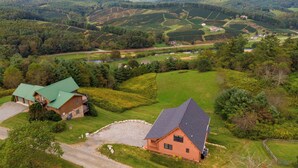 A rural landscape with a large house, a smaller cabin, and a river. - Chasing Clouds Cabin (Fleetwood)
