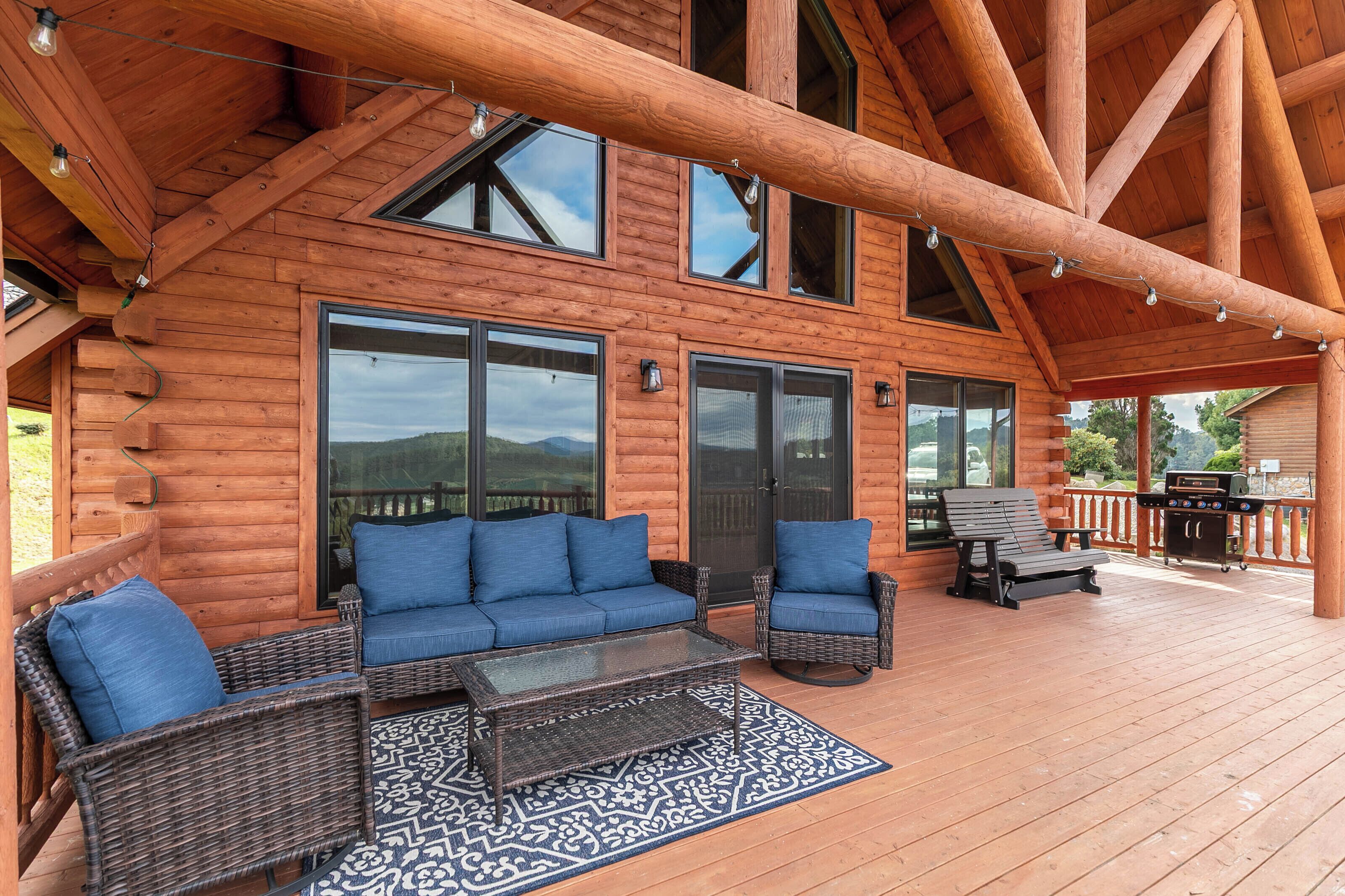 Une cabane en bois dotée d’une terrasse couverte, de grandes fenêtres et de meubles pour s’asseoir à l’extérieur.
