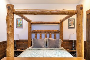A rustic wooden bed with a headboard, checkered bedding, and two pillows. - Ripple Run at Eagles Nest (Banner Elk)