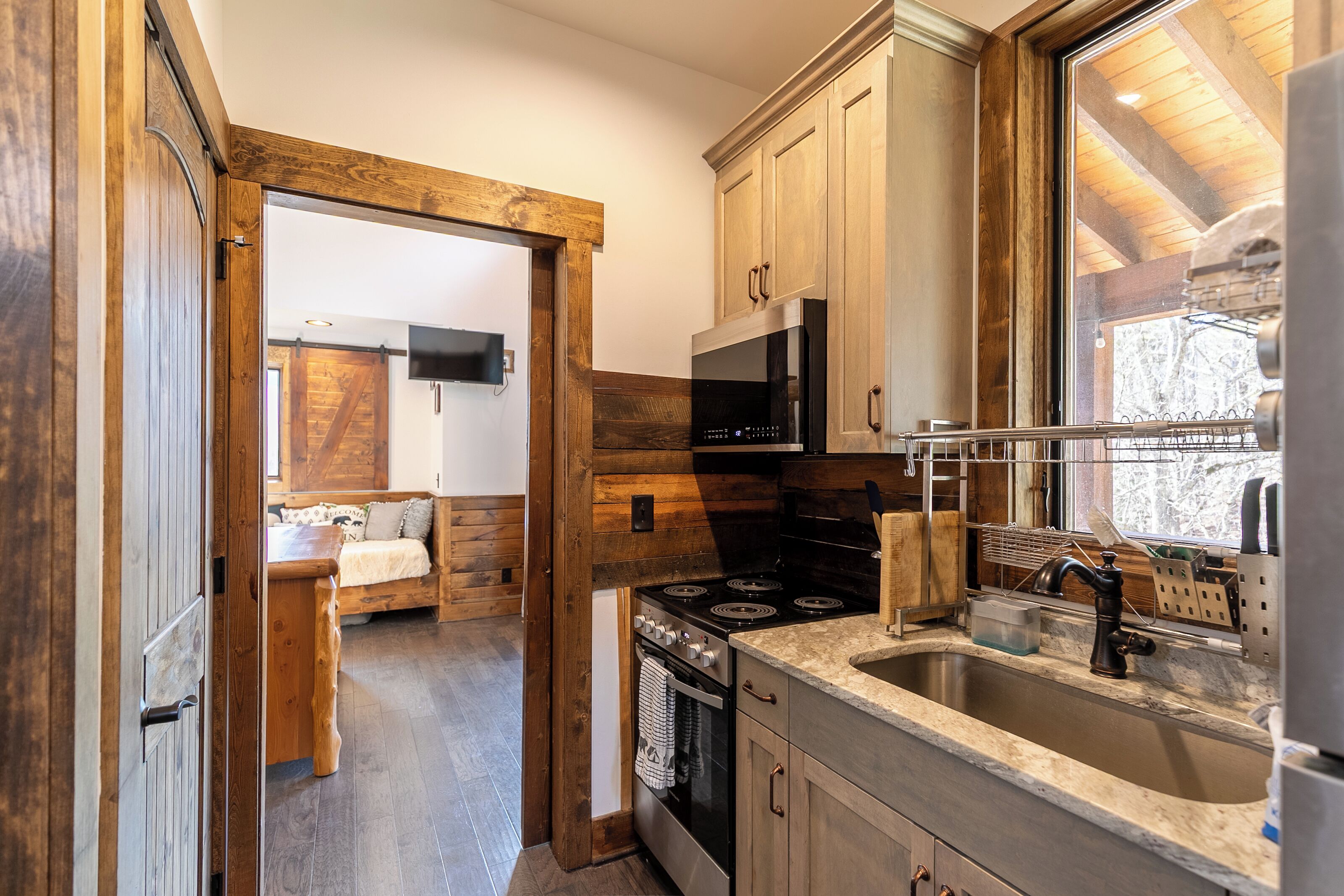 A modern kitchen with wooden cabinets, a stainless steel sink, and a built-in oven.