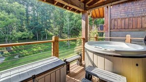 A hot tub on a wooden deck with a view of a forest. - Ripple Run at Eagles Nest (Banner Elk)