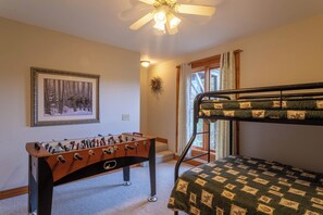 A room with a futsal table, a bunk bed, a framed picture on the wall, and a ceiling fan. - River Ridge (Boone)