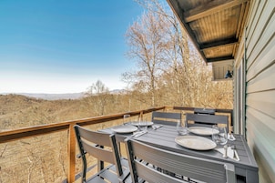 Un comedor con una mesa preparada para cuatro, con vistas a un paisaje pintoresco.