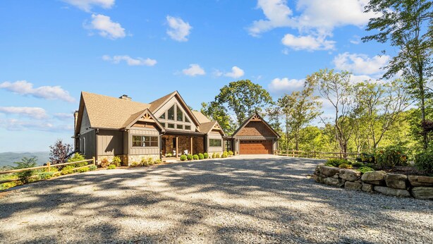 A two-story house with a gravel driveway and stone walls. - Altitude Adjustment at Eagles Nest (Elk Park)