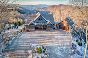 A large, two-story house with a spacious front yard and a garage. - Altitude Adjustment at Eagles Nest (Elk Park)