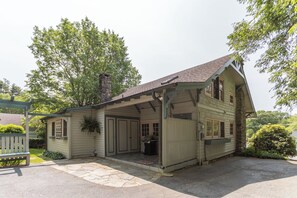 A two-story building with a stone chimney, a covered porch, and a stone-paved entrance. - The Suddreth Cottage (Blowing Rock)