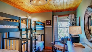A cozy room with bunk beds, a desk, a chair, and a lamp. - Owls Nest (Blowing Rock)
