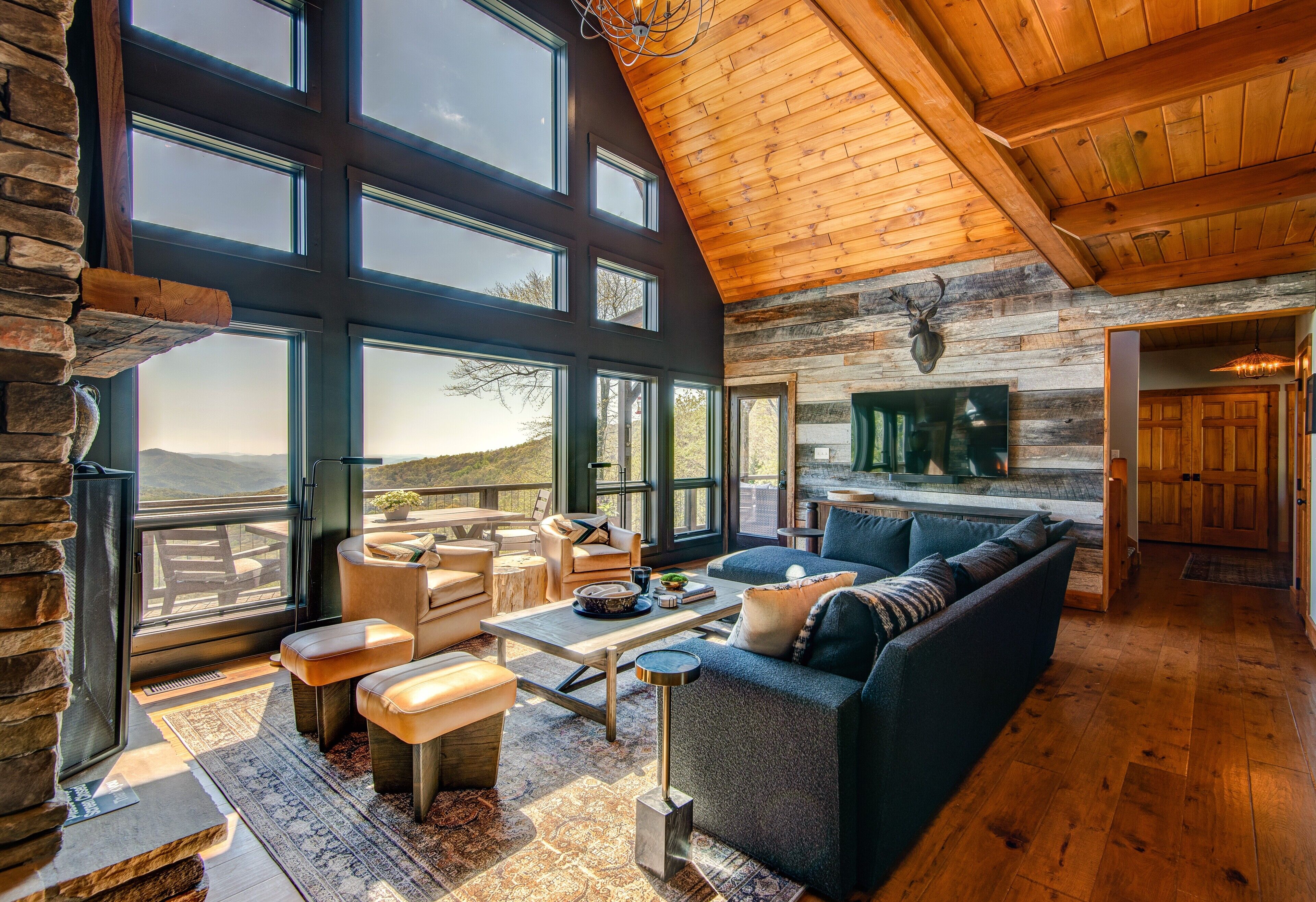 A spacious living room with a large window, a fireplace, and a cozy seating area.