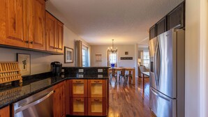 A kitchen with wooden cabinets, a stainless steel dishwasher, and a large refrigerator. - Petes Alpine Retreat (Banner Elk)