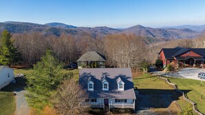 A two-story house with a large front porch, a garage, and a driveway. - Petes Alpine Retreat (Banner Elk)
