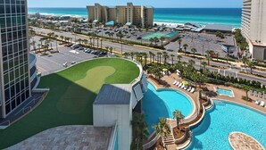 A hotel with a pool, a golf course, and a view of the beach and ocean. - Laketown Wharf 809 (Panama City Beach)